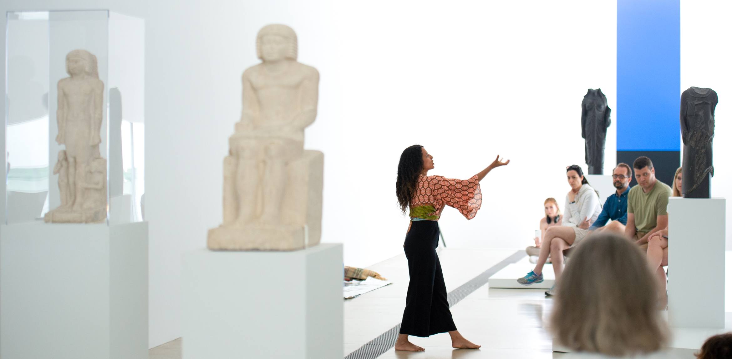 Odeya Nini performs in the Main Gallery for audience members, Egyptian statues on display.