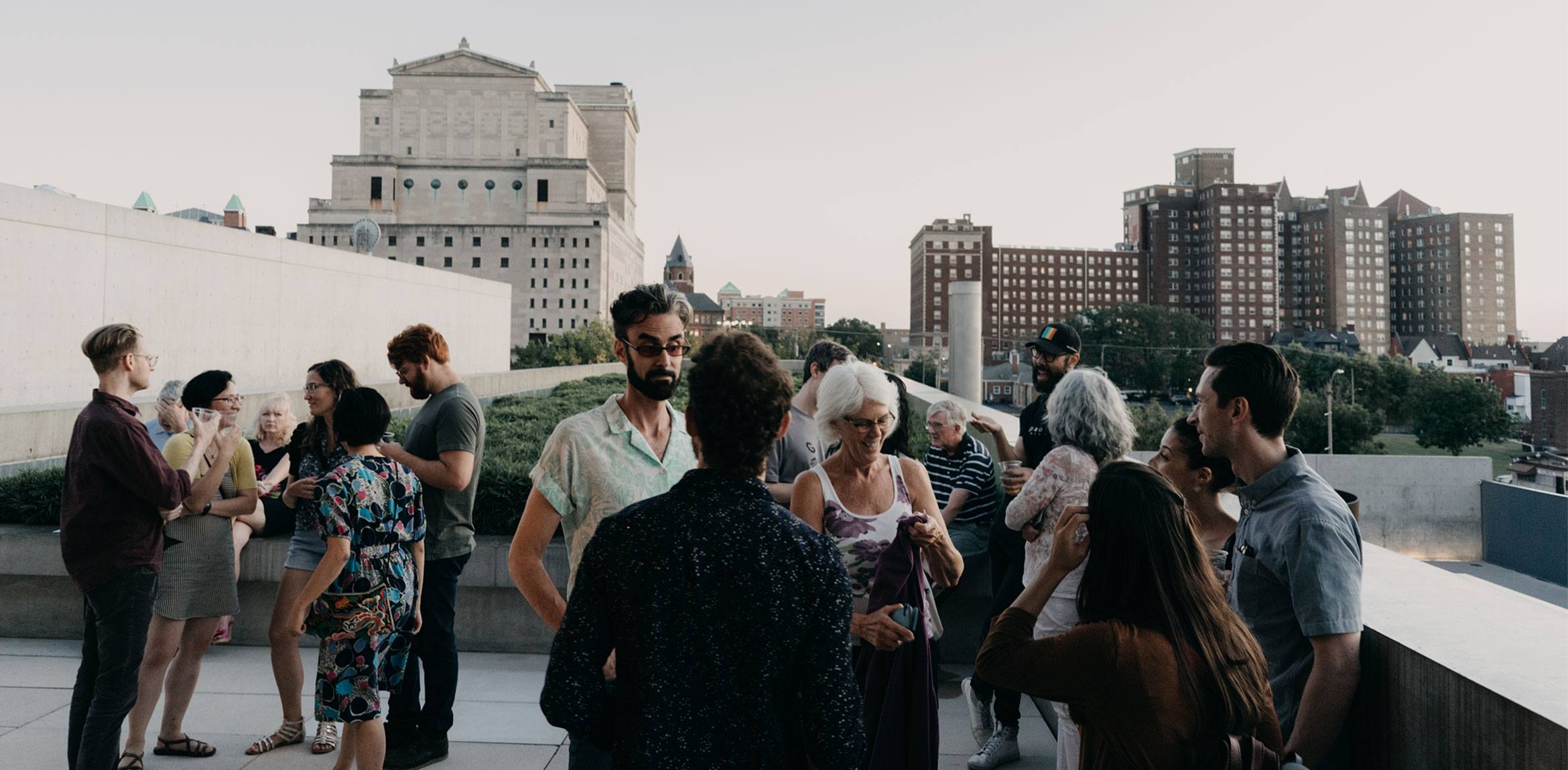 Visitors congregate on the Mezzanine patio with the Grand Center skyline in the distance.