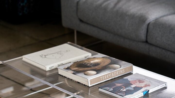 A clear coffee table with books and a couch in the Mezzanine.