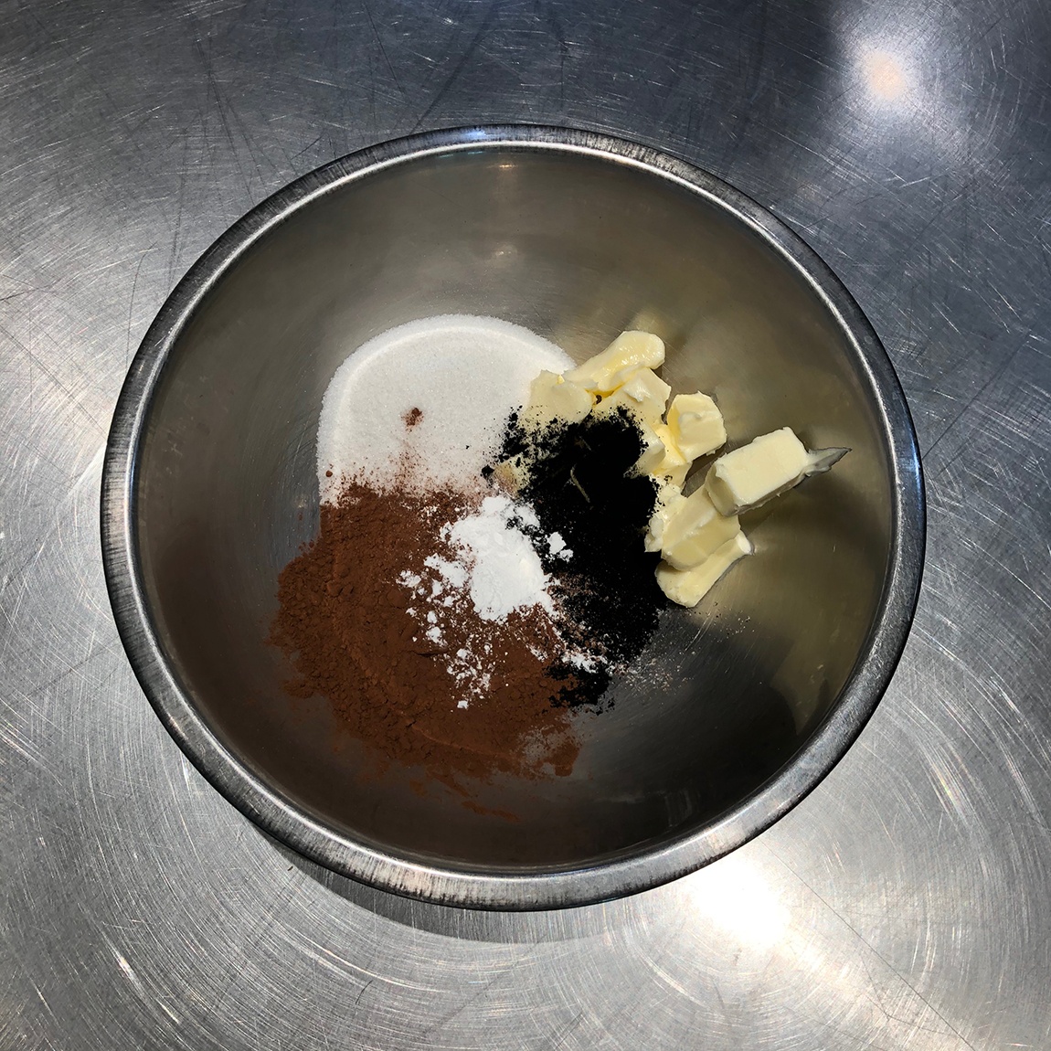 A view of unmixed ingredients in a metal mixing bowl.