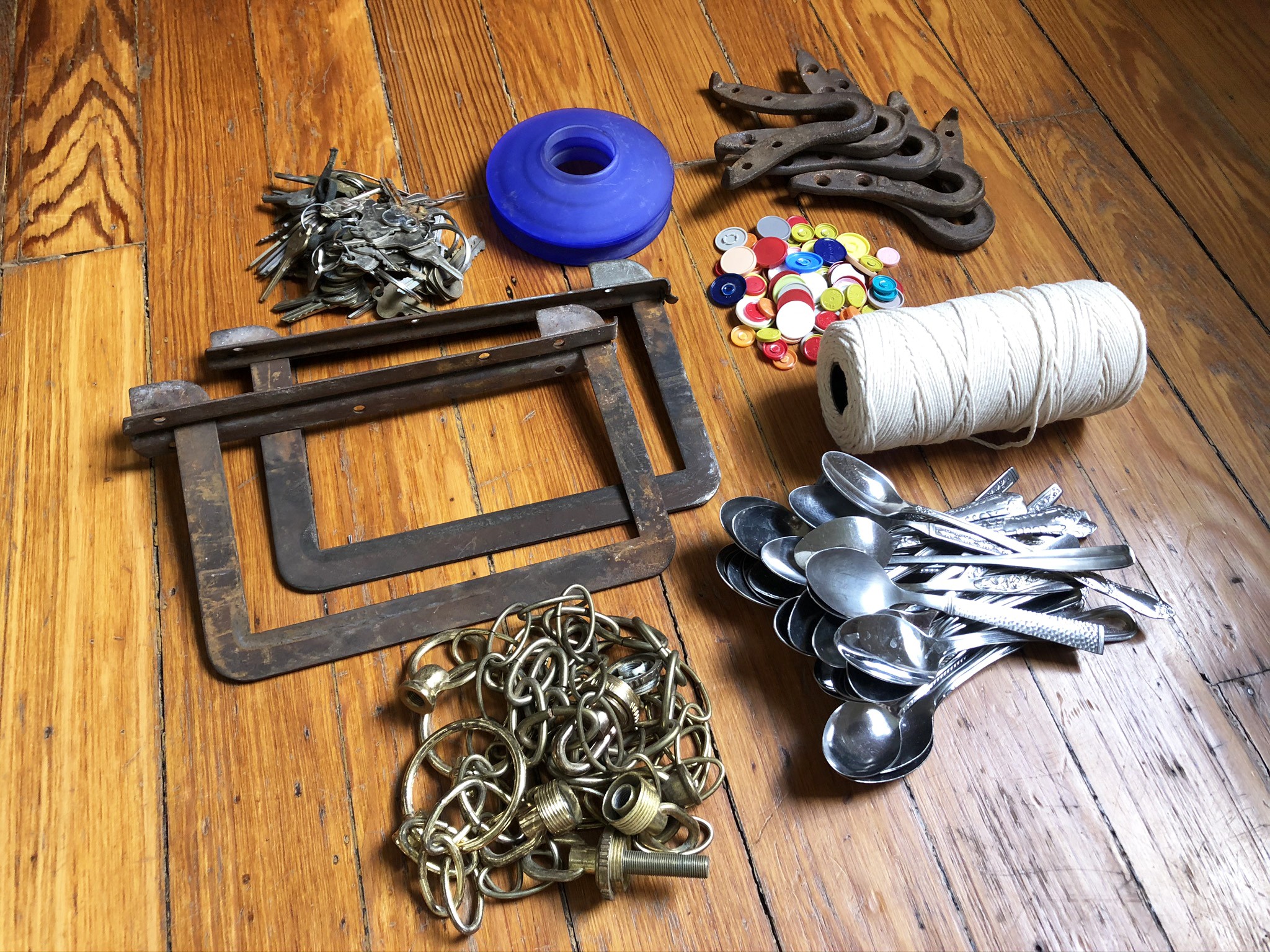 Supplies for the activity laid out on a wood table, including spoons, string, and keys.