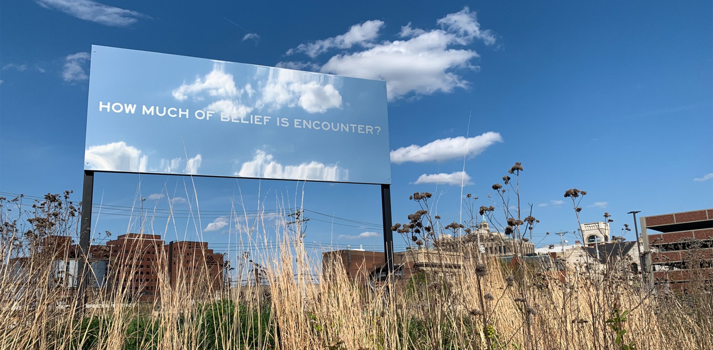 A mirrored billboard work with text by Chloë Bass installed outdoors in Park-Like