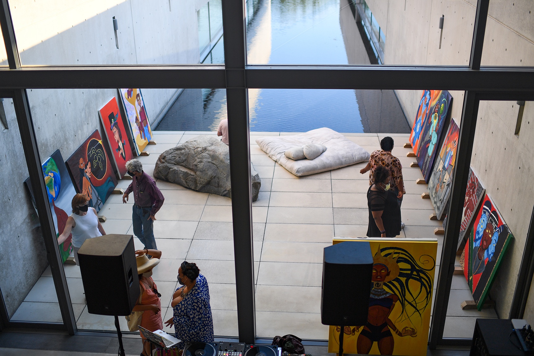 View of the museum water court, with people socializing amongst a pop-up exhibition