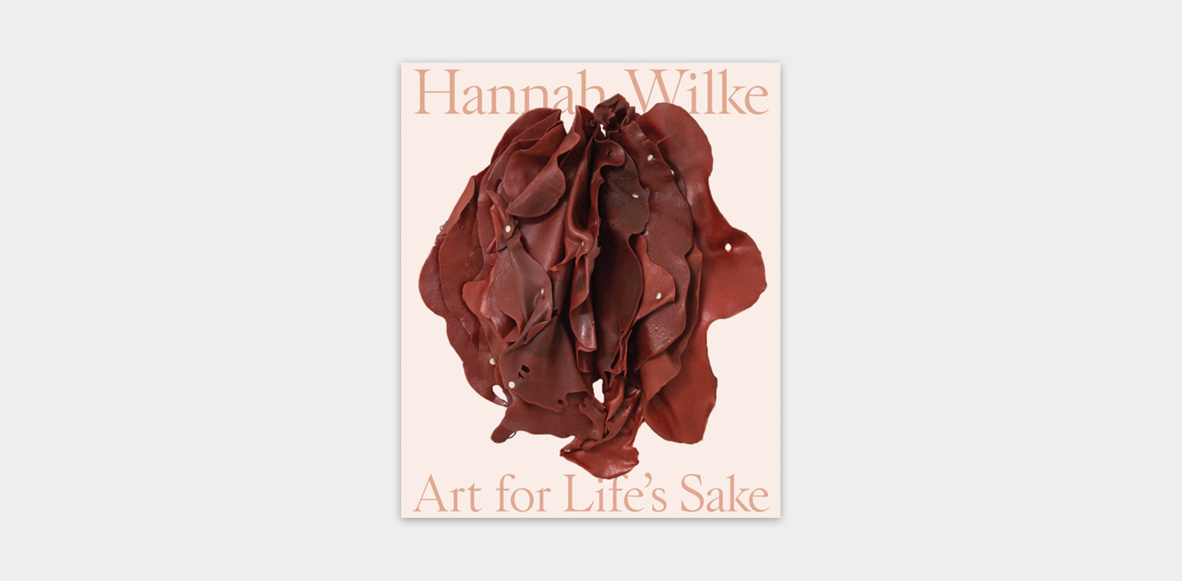 Publication cover for Hannah Wilke: Art for Life's Sake featuring a light pink background, beige text, and an image of a red latex sculpture by Wilke