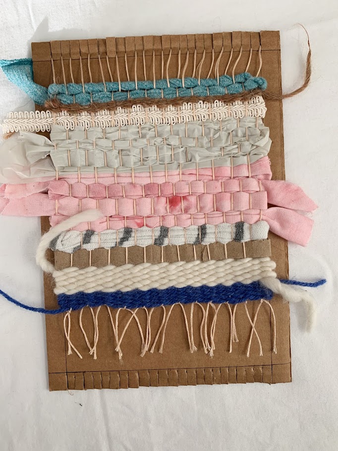 A cardboard loom woven with colorful fibers