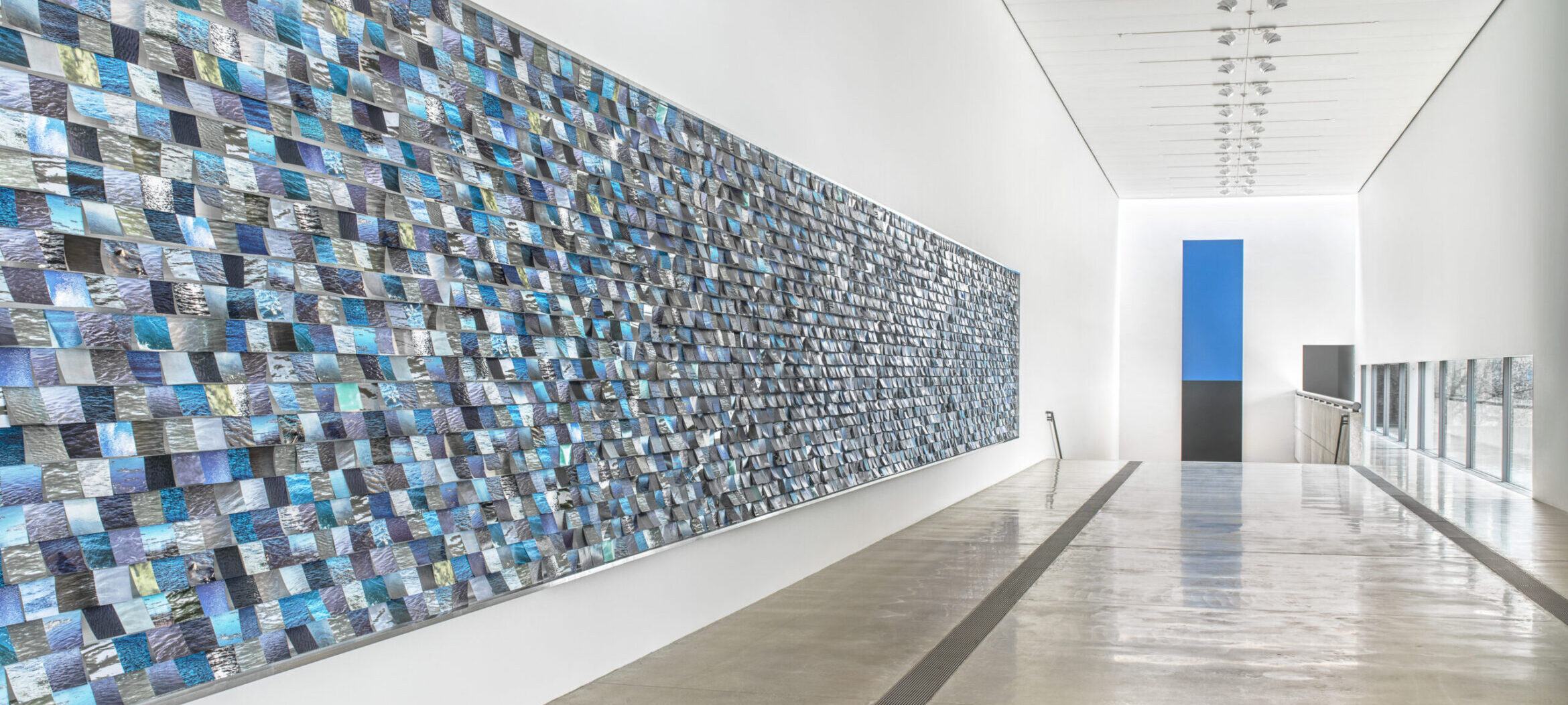 Large horizontal installation with 3,500 rectangular photographs of various rivers.