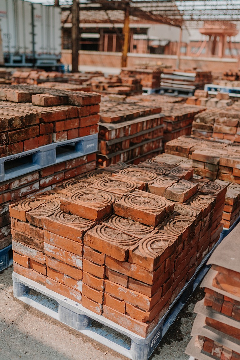 Multiple pallets containing stacks of ornamental bricks outside the National Building Arts Center.