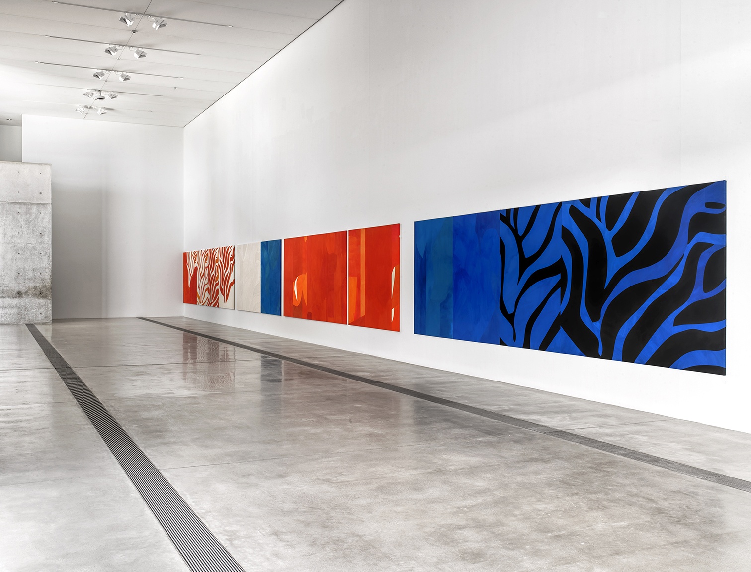 View of the Pulitzer's main gallery with a large scale orange, blue and black abstract paintings hung on the wall.