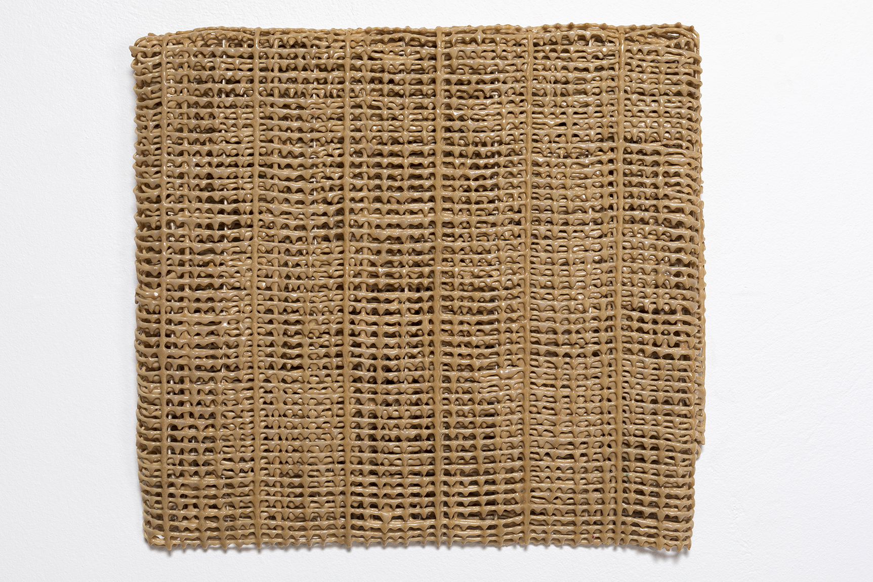 A muted brown distressed fabric-like acrylic on cotton thread resembling netting hanging on a white gallery wall