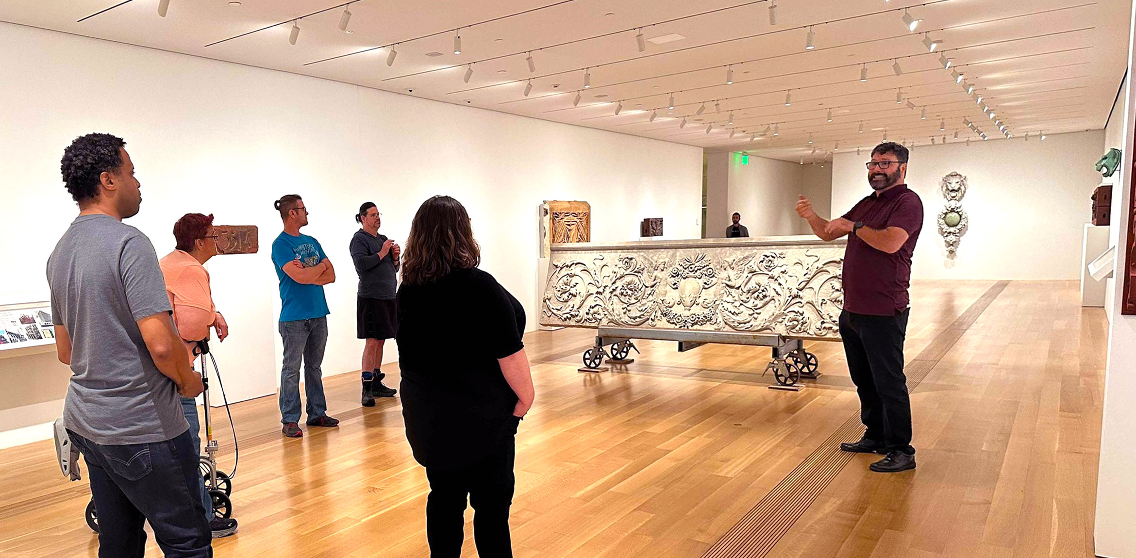 An ASL guide leads a tour at a museum gallery