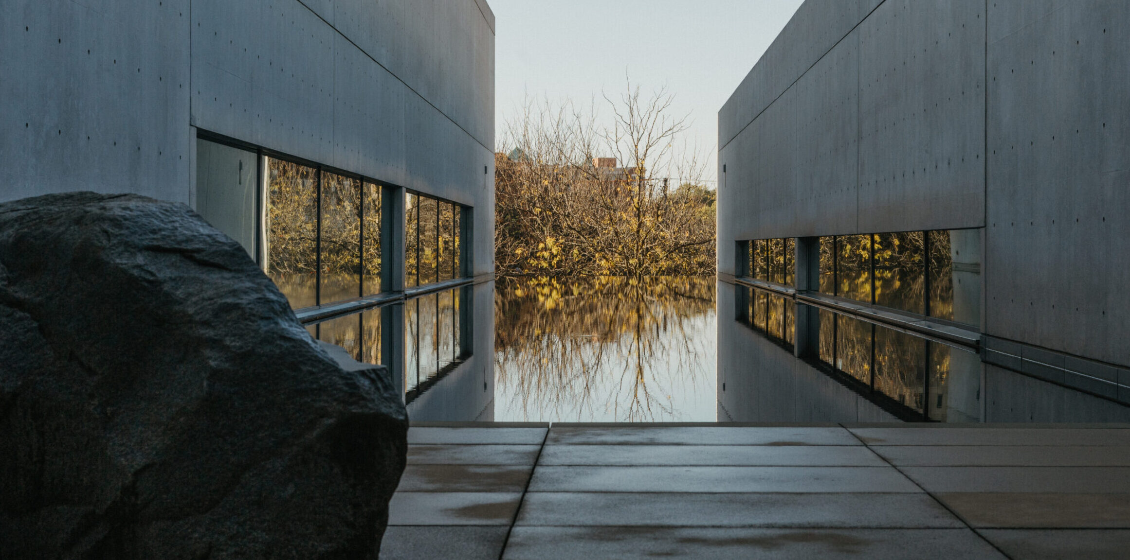 Pulitzer watercourt with Rock Settee sculpture with fall trees in the background