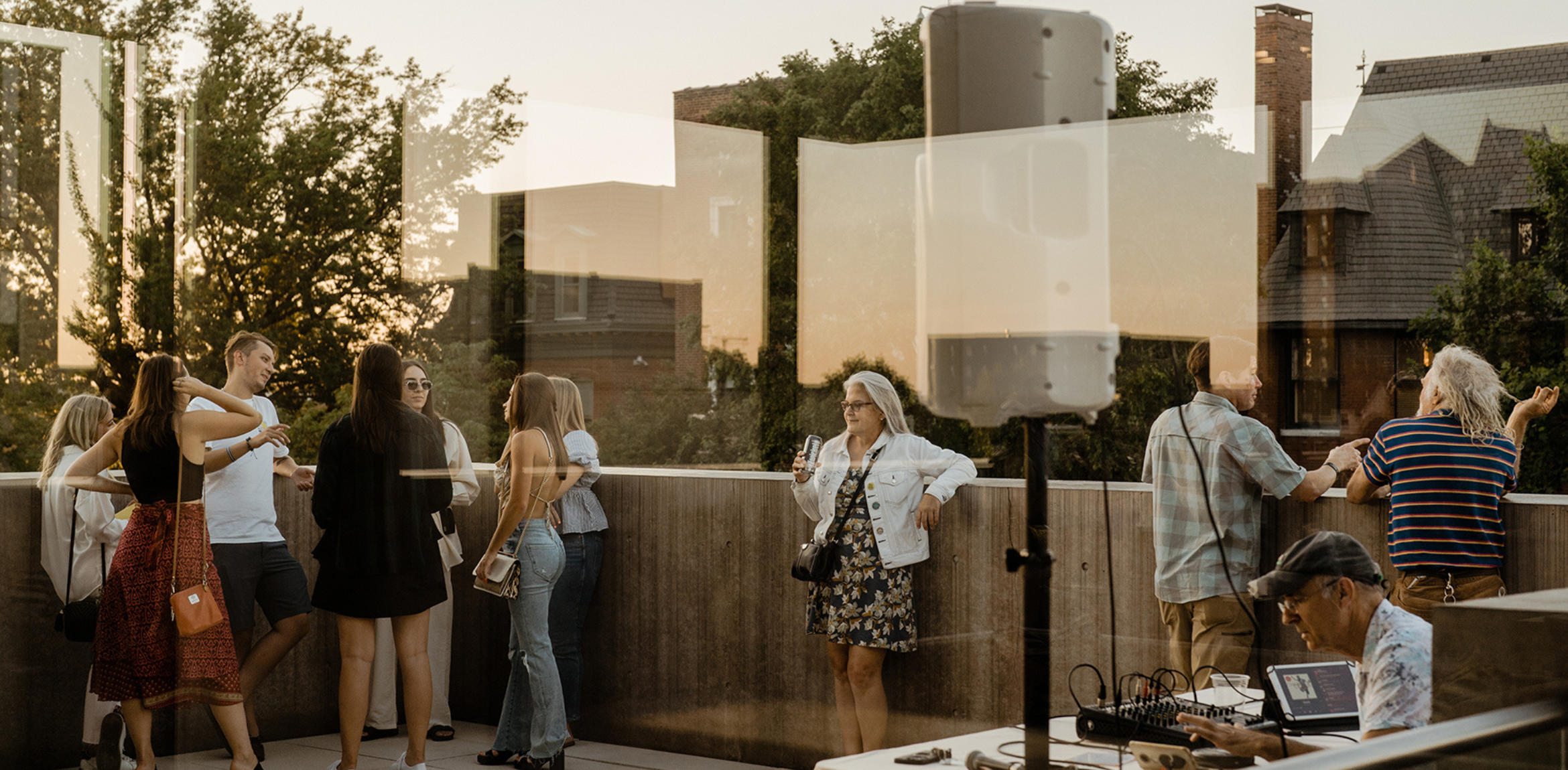 Group of people gathering and mingling on the rooftop mezzanine level of the Pulitzer Arts Foundation.