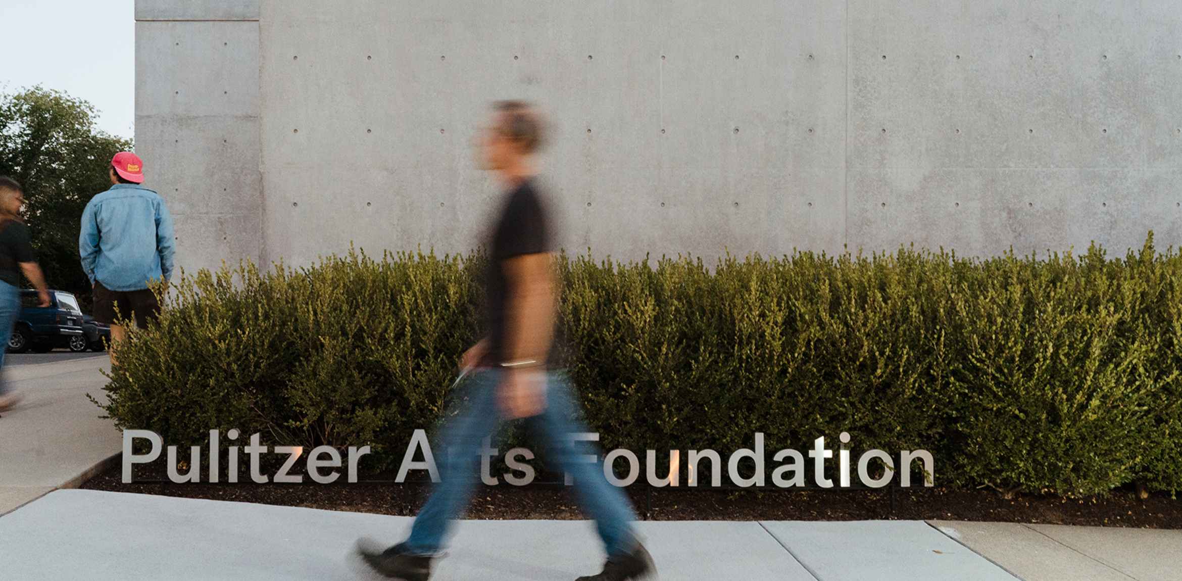A blurred man walking in front of the Pulitzer Arts Foundation entrance